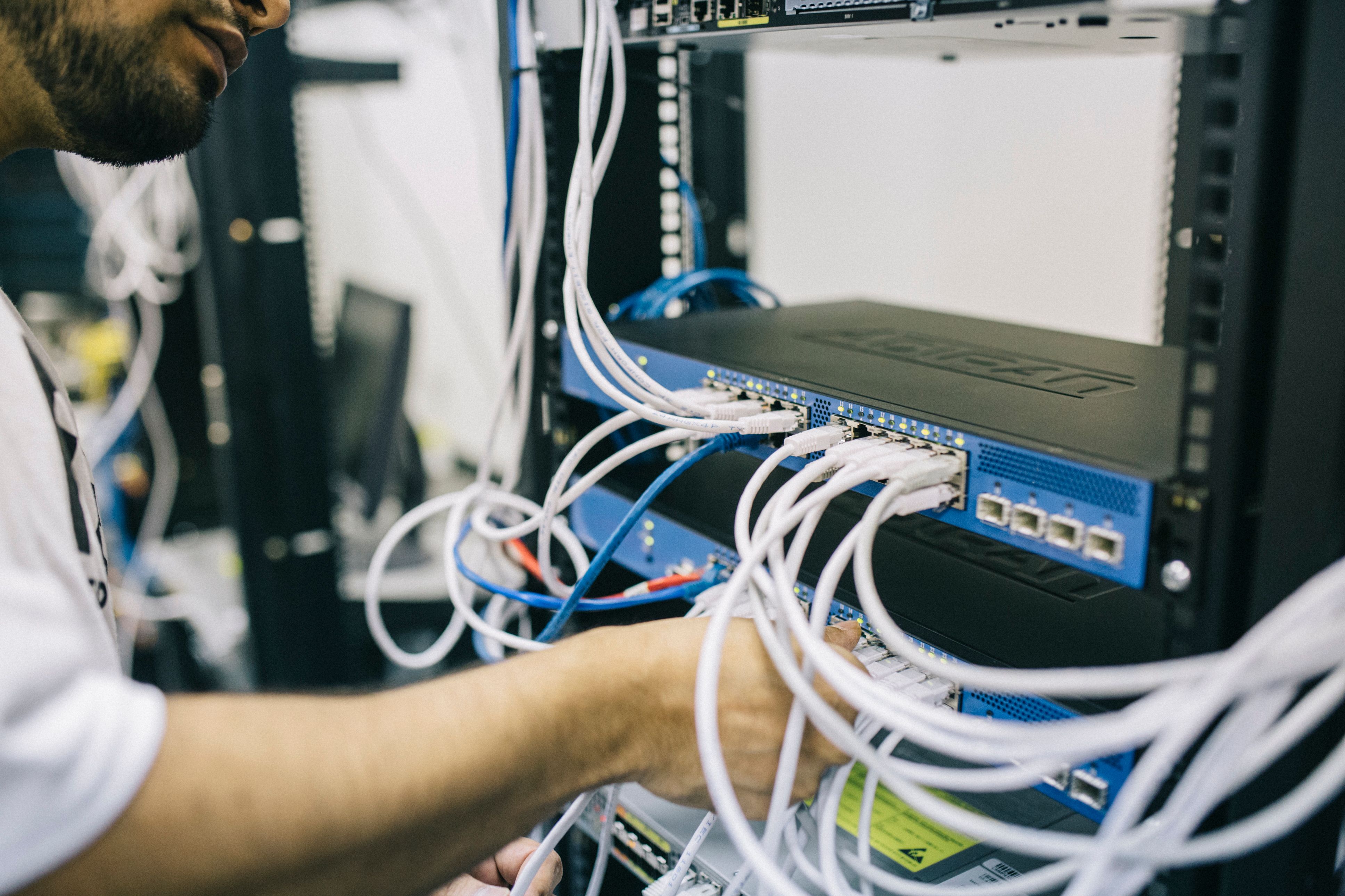 Technicien informatique travaillant avec un rack de serveurs réseau